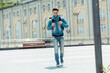 © LIGHTFIELD STUDIOS - Selective focus of positive courier with thermo backpack walking on urban street at daytime