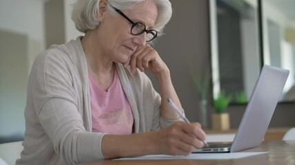 Wall Mural - Senior woman using laptop computer at home