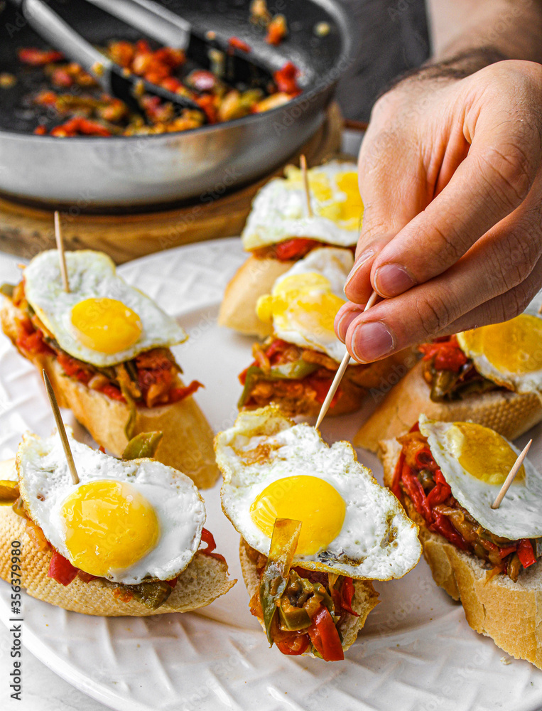 Basque pintxo made with onion, red & green pepper topper with a small ...