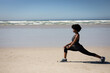 © Wavebreak Media - Side view of woman stretching at the beach