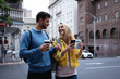 © Wavebreak Media - Caucasian couple on the go in the city holding a take away coffee and phone