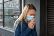 © Wavebreak Media - Caucasian woman wearing a covid19 coronavirus mask outside and coughing