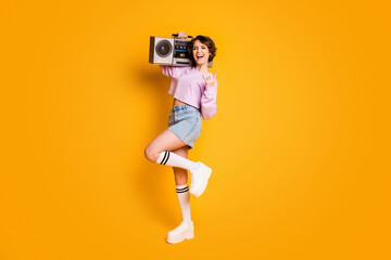 Poster - Full size photo of crazy funny teen want listen rock song music hold boom box enjoy rejoice show horned symbol wear pink white sweater jumper denim isolated over bright shine color background