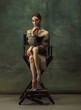 © master1305 - Beautiful portrait. Graceful classic ballerina dancing, posing isolated on dark studio background. Stylish trench coat. Grace, movement, action and motion concept. Looks weightless, flexible.