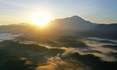 Scenery of Mount Kinabalu forest with low clouds on the morning from aerial scene.