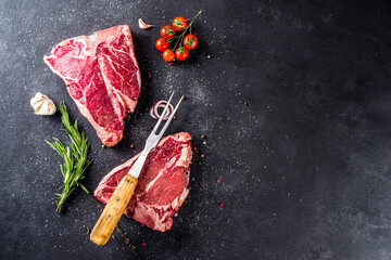 Wall Mural - Cooking meat background. Raw aged beef t-bone steak, with spices and herbs for cooking on a gray table background top view