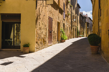 Poster - Sunny streets with colorful flowers with contrasting shades. Walk the Tuscan town