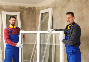 Wall Mural - Workers in uniform with new plastic window indoors