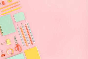 Layout of colorful school supplies on a pink pastel background. Creative stationery flatlay with copy space.