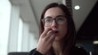 © Vital9c - Young woman eating fried potatoes. A girl sits in a cafe by the panoramic window and eats fast food.