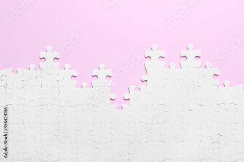 Fotografía White puzzle on pink background, flat lay