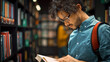 © Gorodenkoff - University Library: Talented Hispanic Boy Wearing Glasses Standing Next to Bookshelf Reads Book for His Class Assignment and Exam Preparations. Side View Portrait