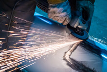 Man Polishes Metal. Master Works With A Grinding Machine. Leveling Material. Concept - Alignment Of Car Body. Body Work In A Car Workshop. Sparks Fly From Under Grinding Machine. Angle Grinder