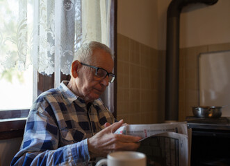 Wall Mural - Old man reading newspaper at home