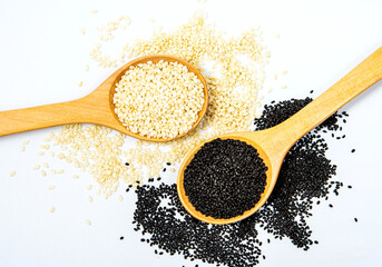 white and black sesame seeds with spoon isolated on white background