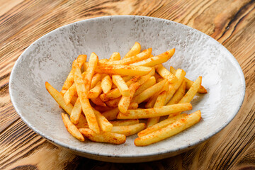 Wall Mural - french fries in a plate on a wooden background