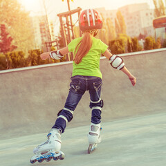 Wall Mural - Little girl in helmet on roller-skates in park, back view