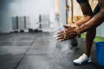 Fitness man rubbing hands with chalk magnesium powder.