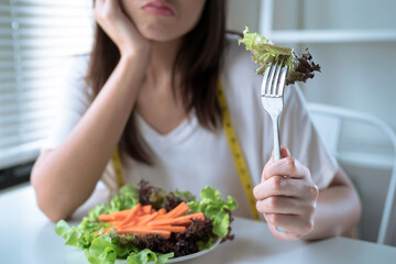 Unhappy asian girl, She was bored when she had to eat vegetables.