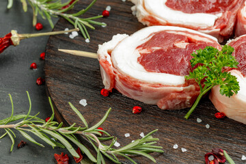 Wall Mural - fresh meat with ingredients for cooking on dark background