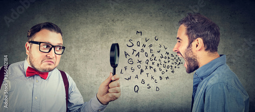 Cuadros en Lienzo Curious businessman looking through a magnifying glass at an angry screaming man