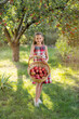 © Hanna - Beautiful girl harvests apples. Apple orchard. The child holds apples and a basket with apples in his hands. A walk in the garden. Long-haired girl smiles and walks in nature