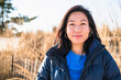 © Cavan Images - Closeup Portrait of Asian Woman outdoors smiling at the beach