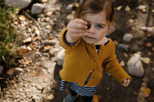Young Girl Holding Up A Rock Covering Her Eye In The Fall