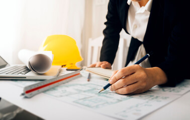 Two colleagues discussing data working and tablet, laptop with architectural project at construction site at desk in office