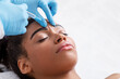 Leinwandbild Motiv Young black woman receiving botox injection at beauty salon