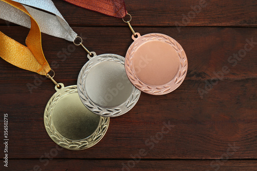 Cuadros en Lienzo Gold, silver and bronze medals on wooden background, flat lay