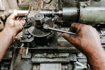 Wall Mural - Close up shot of manual worker hands. Factory for industrial production of hydraulic hoses.