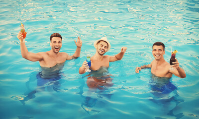 Wall Mural - Happy young friends with refreshing cocktails in swimming pool