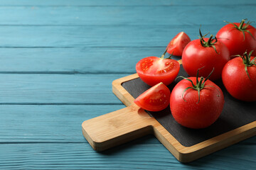 Fresh tomatoes on board on wooden table. Ripe vegetable