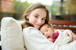 © MNStudio - Cute big sister admiring her newborn brother. Adorable teenage girl holding her new baby boy brother. Kids with large age gap. Big age difference between siblings.