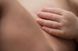 © Gustavo Pozo/ADDICTIVE STOCK - Closeup anonymous nude infant touching soft skin of body while resting at home