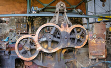 Old Used Rusty Mechanism Made Of Steel Discs Of Various Diameters Mounted On Metal Device In Dirty Abandoned Factory Building