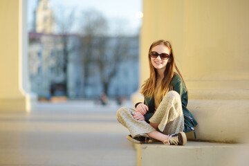 Wall Mural - Cute young girl sightseeing on the streets of Vilnius, Lithuania on warm and sunny spring day.