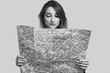 © micro - Studio portrait of pretty young hipster woman with backpack holding map