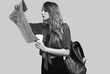 © micro - Studio portrait of pretty young hipster woman with backpack holding map