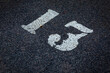 © LariBat - White number 13 on the pavement. Unlucky or happy parking place