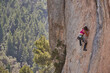 © PHILIPPE DEGROOTE/ADDICTIVE STOCK - From above active female alpinist in sportswear with rope and safety equipment ascending rocky slope of high mountain on sunny day