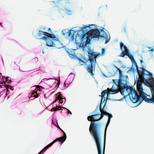 Translucent Vibrant Pink And Blue Smoke Whiffs And Swirls Of Aromatic Colorful Incense Against White Background