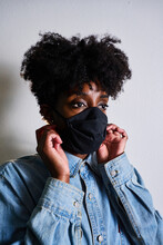 Young African American Female In Casual Denim Shirt And Black Protective Mask Looking Away While Staying At Home During Coronavirus Outbreak