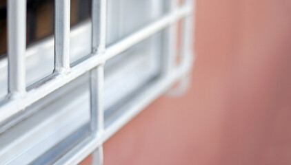 The window home made from white metal with orange concrete cement wall and blue wooden door decoration outside home, vintage style home design concept, selective focus blurred foreground.