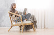 © Prostock-studio - Young Arabic Girl Relaxing In Modern Chair With Coffee And Digital Tablet