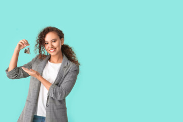 Wall Mural - Happy young woman with key on color background