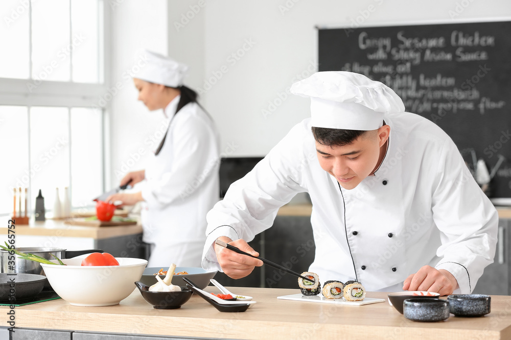 Asian chefs cooking together in kitchen