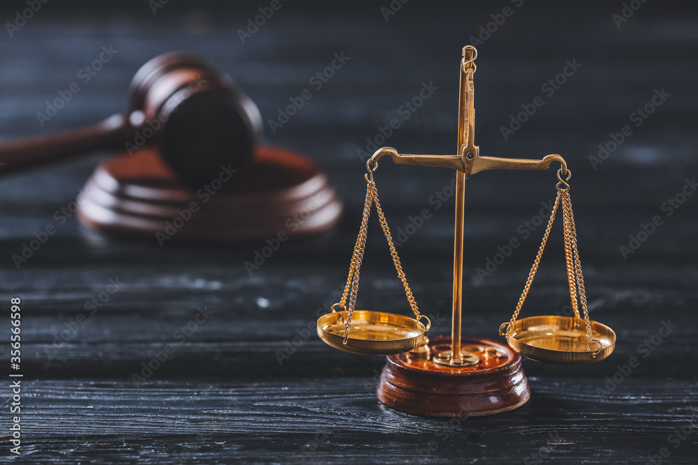 Scales of justice on dark wooden background