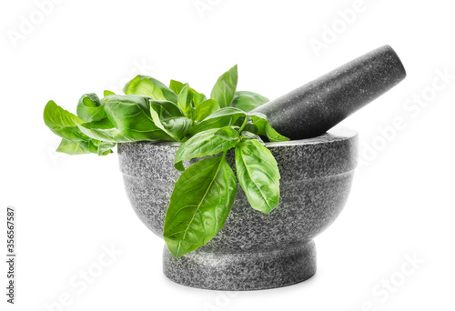 Fotografía Mortar and pestle with fresh green basil isolated on white